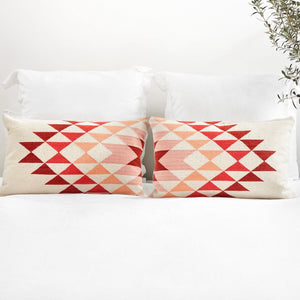 Set of Two Blush and Pink Lumbar Pillows on Bed